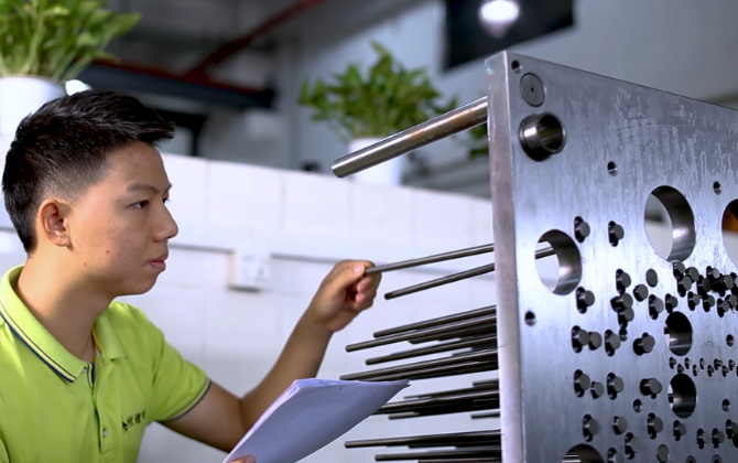 Engineer inspecting shoulder ejector pin application inside precision mold system